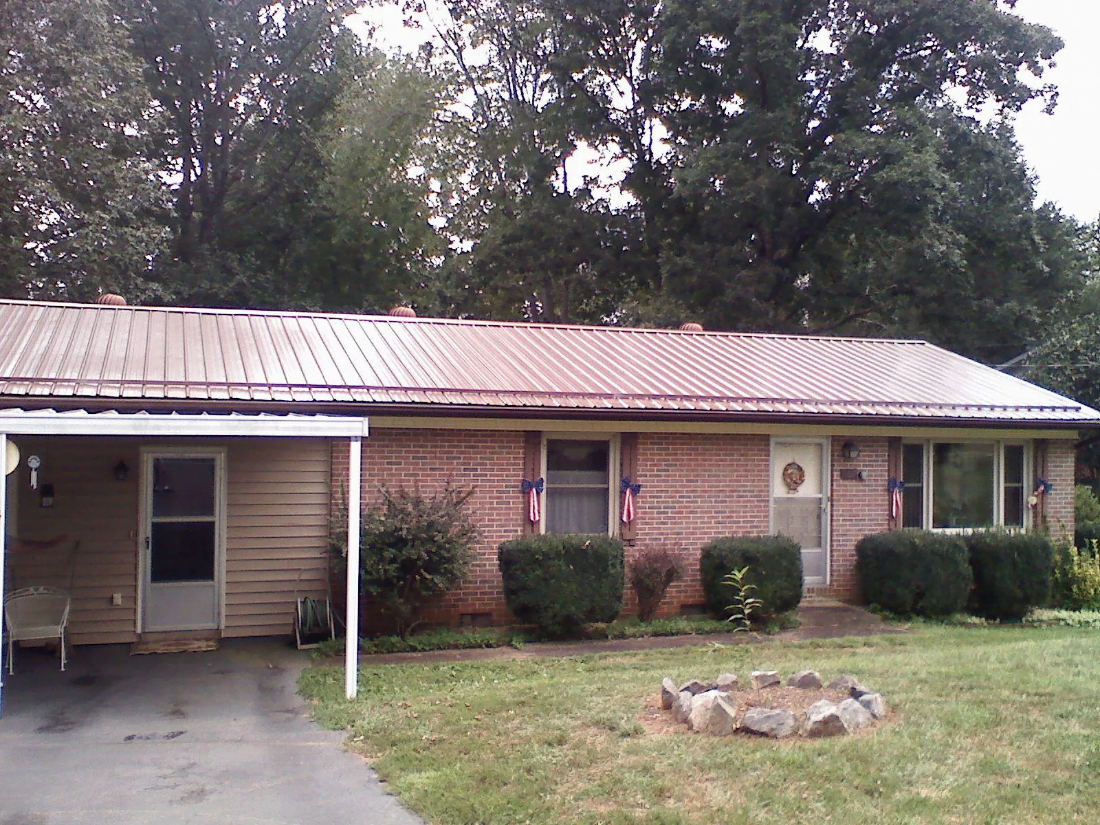Bronze metal roof and carport on a brick ranch home — Roof Repair work by our crew in Owensville